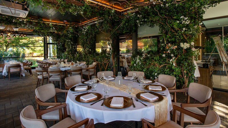 Garden Room with focus on round table set for many guests - Sear House - Gallery Photo 1 Garden Room with focus on round table set for many guests